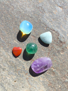 Set de piedras para Acuario con amatista, aguamarina, fluorita, cornalina y opalina sobre fondo de piedra