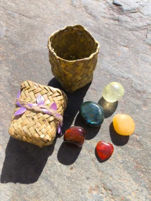 Set de Leo con piedras pulidas presentadas junto a cesta natural sobre superficie de piedra