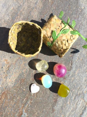 Piedras pulidas del set de Virgo dispuestas junto a cesta natural sobre superficie de piedra