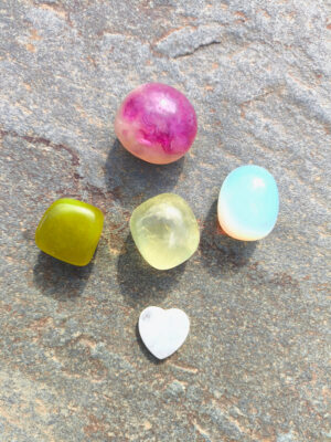 Piedras pulidas del set de Virgo dispuestas sobre superficie de piedra natural