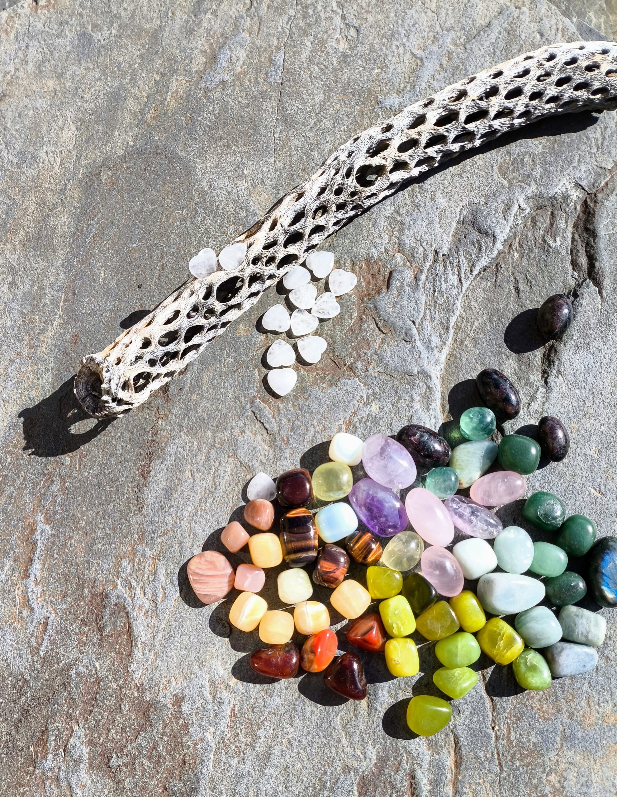 Composición de piedras pulidas de colores dispuestas de forma desordenada sobre superficie natural