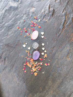 Disposición vertical de piedras pulidas del set de sanación emocional sobre superficie de piedra