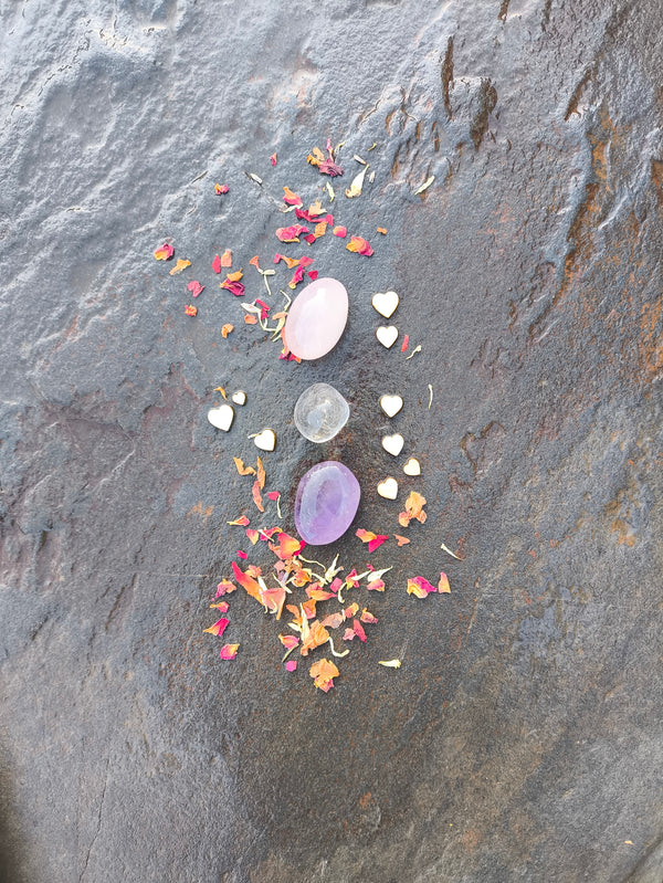 Disposición vertical de piedras pulidas del set de sanación emocional sobre superficie de piedra