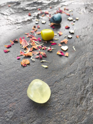 Set de creatividad y creación artística con citrino, jade y amazonita pulidos dispuestos en composición vertical sobre superficie de piedra