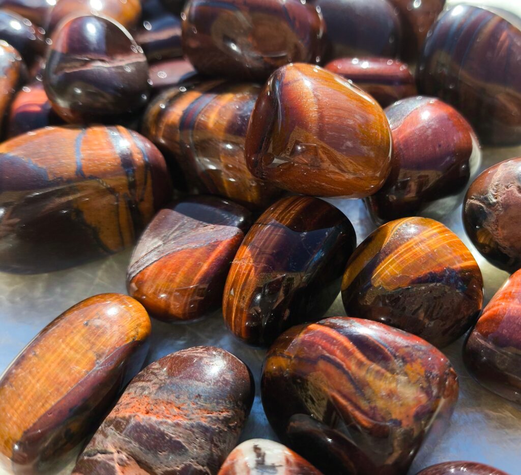 Ojo de toro pulido con vetas marrón rojizas y doradas, piedra de fuerza, protección y estabilidad.