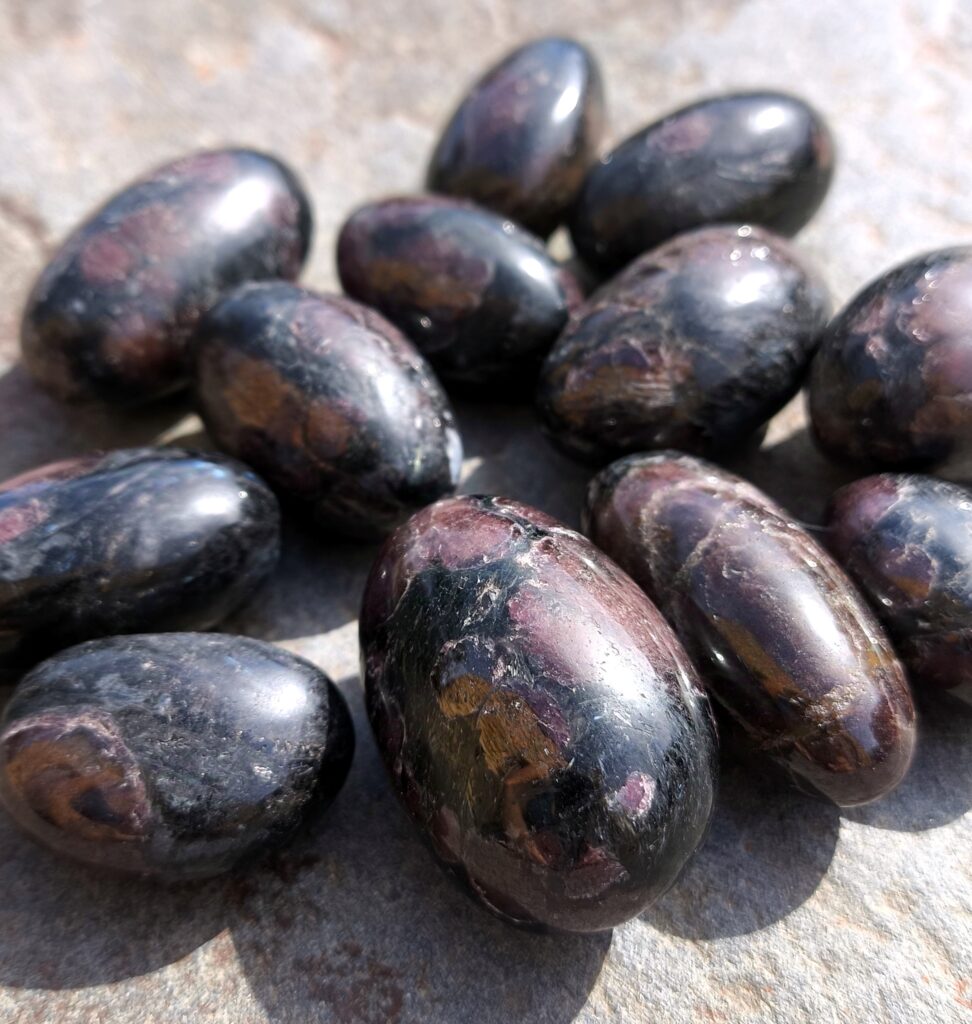 Granates pulidos en tonos rojo oscuro y negro, piedra asociada a la fuerza, la vitalidad y la energía de Aries.